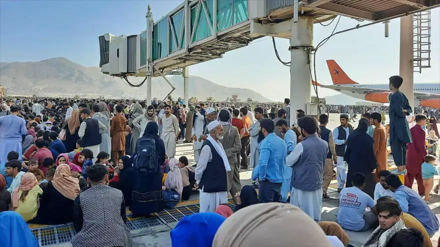 Afganos intentan acceder a un avión en el aeropuerto de Kabul, este lunes. En vídeo, caos en el aeropuerto de Kabul con cientos de afganos intentando huir.