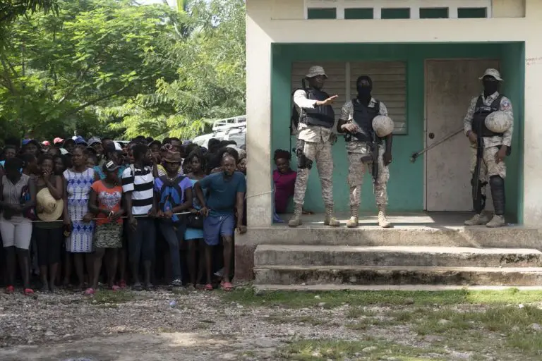 La policía de Haiti resguarda la escuela durante la entrega de alimentos.