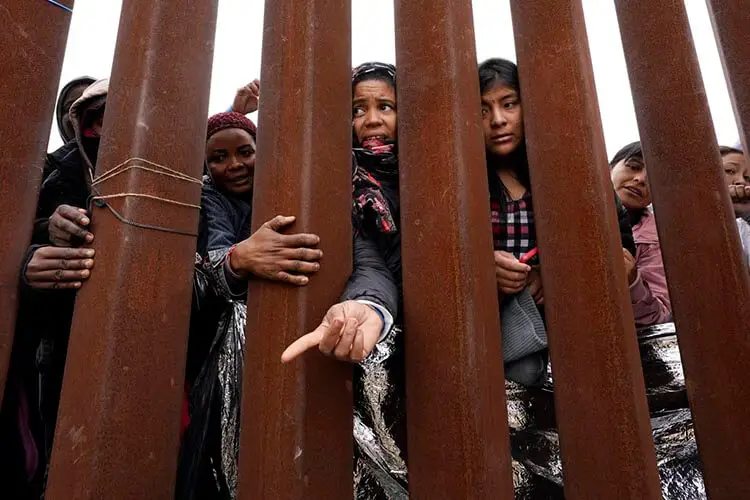 Migrantes aguardan en la frontera entre Estados Unidos y México