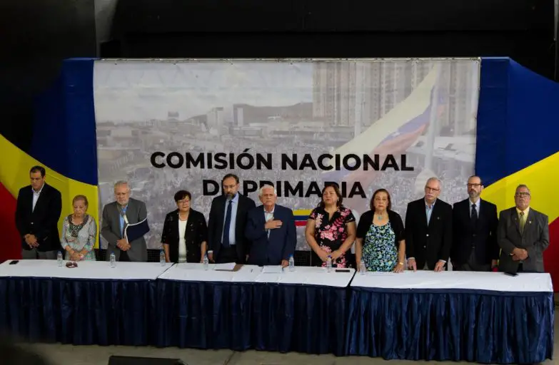 La Comisión Nacional de Primaria (CNP) aclaró este miércoles que explicará a los precandidatos presidenciales el alcance del posible acuerdo que logre alcanzar con el Consejo Nacional Electoral (CNE) antes de formalizar la solicitud de asistencia técnica para los comicios de la oposición fijados para 22 de octubre. A través de un comunicado, la instancia informó que mantiene «cauces permanentes de comunicación» con todos los candidatos a la primaria. Esto, afirmó, permite canalizar las dudas u observaciones que puedan tener cada uno de ellos. La CNP recalcó que todas las solicitudes formuladas al CNE son «de conocimiento público». Incluidas, detalló, las referentes a la protección de la identidad de los electores, según las especificaciones realizadas por los técnicos electorales de la comisión. «El pasado 6 de junio de 2023 se notificó a los precandidatos que se les explicaría el alcance de lo que llegare a confirmarse en la Comisión Técnica conjunta antes de formalizar la solicitud de asistencia técnica», dice el comunicado. Además, les recuerda a los precandidatos y voceros que todas las preguntas o dudas están respondidas en los reglamentos que ha publicado la CNP.