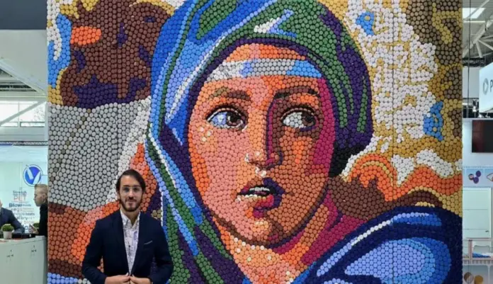 El artista venezolano Óscar Olivares presentó un nuevo mural en la feria Drinktec de Múnich, Alemania, creado con 8,000 tapas de botellas